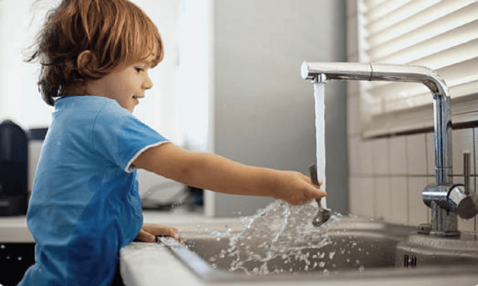 a child washing his hands in a sink